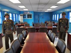 Севрокорейские военные в домике для переговоров на линии разграничения Корей; граница, проходящая через стол. Фото: uritsk.livejournal.com