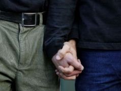 Мужчины держат друг друга за руки. Фото: Getty Images